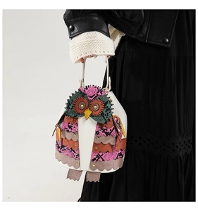Detail of owl-shaped bucket bag featuring colorful patchwork scales and PU leather texture