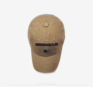 Détail d'une casquette de baseball en coton délavé kaki avec broderie de requin bleue