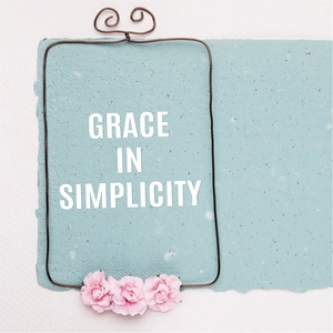 Close-up of Grace In Simplicity lettering on handmade paper with floral frame