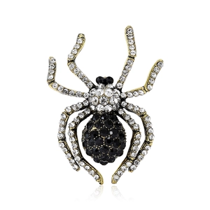 Macro detail of a golden spider brooch with black abdominal gems and clear crystal legs