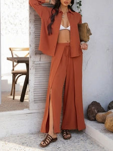 Detail of brick red cotton linen set featuring long sleeve shirt and wide leg tied pants