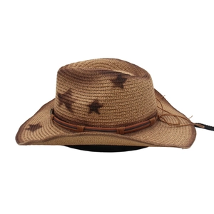 Détail d'un chapeau de cowboy en paille vintage avec motifs d'étoiles et cordon en cuir