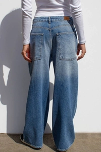 Détail d'un jean large bleu délavé vintage avec de grandes poches plaquées à l'arrière