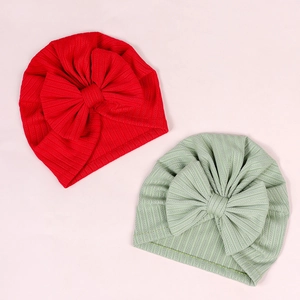 Flat lay of red and bean green ribbed baby headbands with large bow details