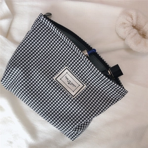 Detail of houndstooth makeup bag with zipper closure and Time to Party label