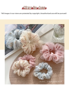 Dettaglio di cinque elastici per capelli in tulle floreale su base in legno con margherite