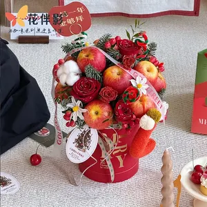 Christmas flower box with red roses and apples in a gold-lettered festive bucket
