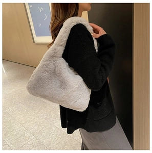 Model wearing a soft light grey plush faux fur underarm bag for autumn winter fashion