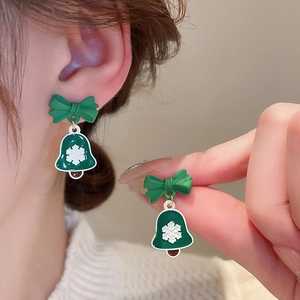 Detail of Christmas bell earrings with green bows and white snowflake patterns