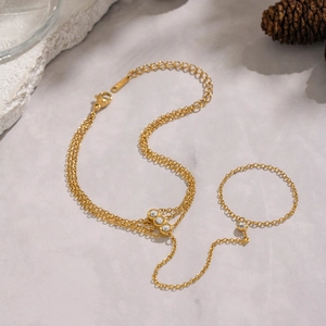 Detail of a 18K gold plated slave bracelet with white zircons on a textured surface