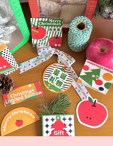 Close-up of Christmas gift tags, stickers and ribbons with holiday patterns on wood