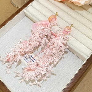 Detail of pink floral lace tassel earrings with beads in a velvet jewelry box