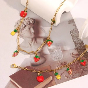 Parure de bijoux en chaîne trombone dorée avec des breloques de fruits en émail coloré