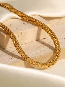 Dettaglio della catena intrecciata placcata oro su pietra e tessuto di seta bianca