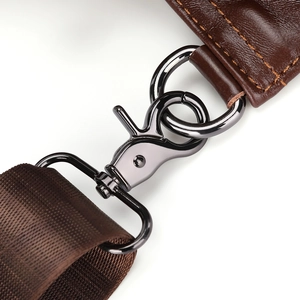 Detail of leather strap joint with orange stitching and dark metal swivel hook