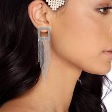 Detail of elegant silver tassel drop earrings with sparkling rhinestones on female model