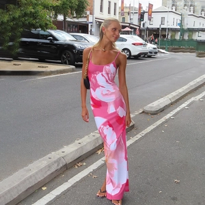 Détail de l'imprimé floral rose sur une robe longue moulante à fines bretelles