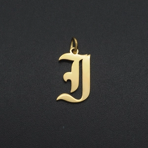 Close-up of golden gothic letter I pendant with a polished metallic finish and ring