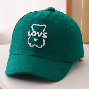 Detailed close-up of bear embroidery and LOVE text on green cotton baseball cap for kids