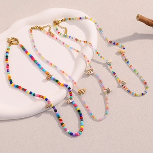 Detailed view of colorful bead necklaces with natural sea shells on a display stand