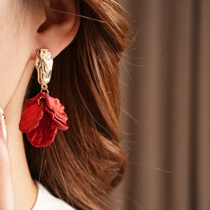 Detail of vintage petal tassel earring with gold metal plate on model ear