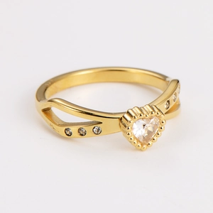 Macro detail of gold heart ring with cubic zirconia and dual hollow band design