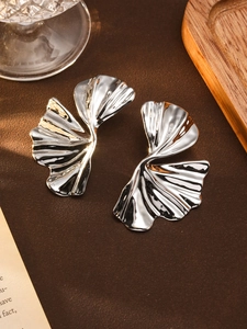 Macro detail of silver abstract floral earrings with textured metallic petals finish