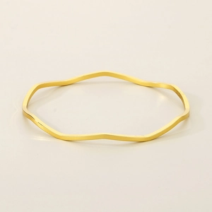 Detail of a wavy gold titanium steel bracelet with a minimalist polished metal finish