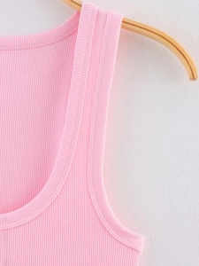 Detail of pink ribbed knit tank top showing fabric texture and neckline on hanger