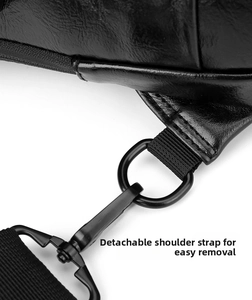 Detail of detachable shoulder strap with black metal lobster clasp and D-ring on chest bag