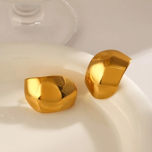 Polished gold plated stainless steel geometric earrings on white ceramic tray