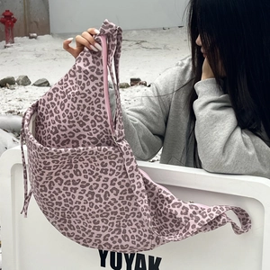 Detail of leopard print suede shoulder bag with zipper closure in snowy outdoor setting