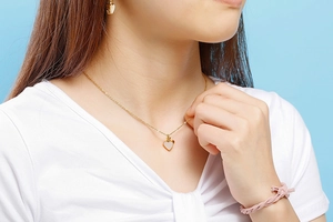 Mannequin portant un collier avec pendentif cœur doré et incrustation nacre blanche