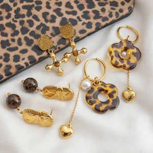 Détail de boucles d'oreilles imprimé léopard avec accents dorés et breloques perles