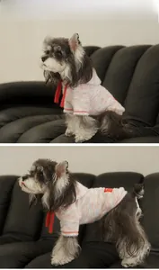 Détail du sweat à capuche rayé pour chien avec cordon rouge sur cuir noir