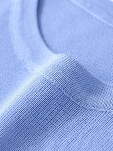 Macro shot showing soft light blue knitted fabric texture and premium stitching details