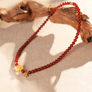 Détail de perles d'agate rouge avec charme ambre et pendentif cœur en diamant