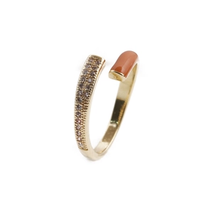 Detail of adjustable gold-plated ring with sparkling zircons and orange enamel accent