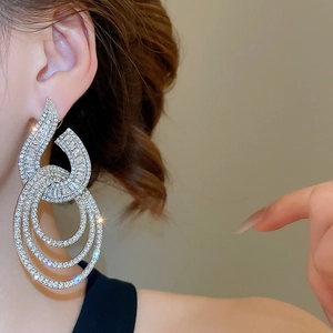 Close-up of elegant silver geometric dangle earrings with shimmering pavé rhinestones