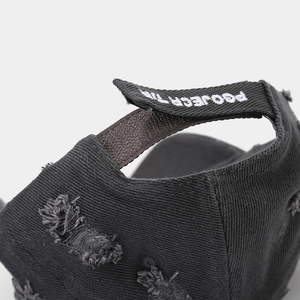 Macro detail of distressed black baseball cap with embroidered adjustable strap