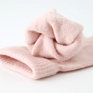 Close-up of soft pink knitted fabric with detailed texture for girls' winter set