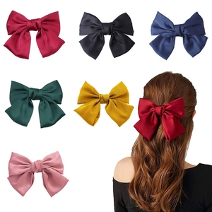 Selection of colorful ribbon bow hair clips including burgundy, navy, and green styles