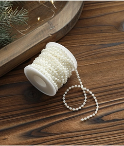 Close-up of white pearl bead string on spool for Christmas DIY tree and wedding decoration