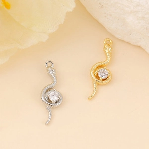 Detailed view of silver and gold snake pendants with sparkling cubic zirconia accents