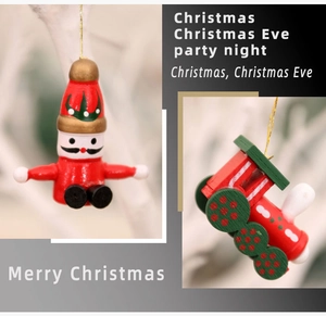 Close-up of wooden Santa and train ornaments hanging on a white decorative Christmas tree