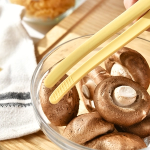 Yellow silicone food tongs with non-slip texture for BBQ and baking in kitchen setting