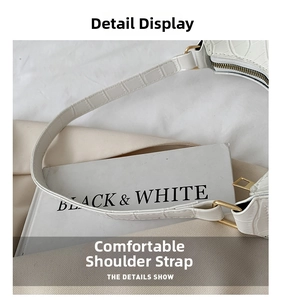 Detail of white crocodile embossed leather strap with gold metal buckle and zipper