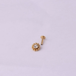 Détail d'un piercing fleur doré 16G avec diamant central et micro billes métalliques