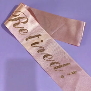 Nahaufnahme der rosa Satinschärpe Retired mit glänzendem Goldglitzer und Textur