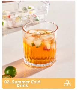 Vertical textured glass cup for summer cold drinks with ice cubes and fresh lime detail